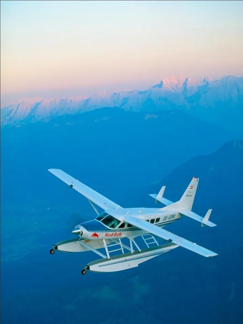 The Flying Bulls Amphibious Caravan soaring over the mountains at sunset